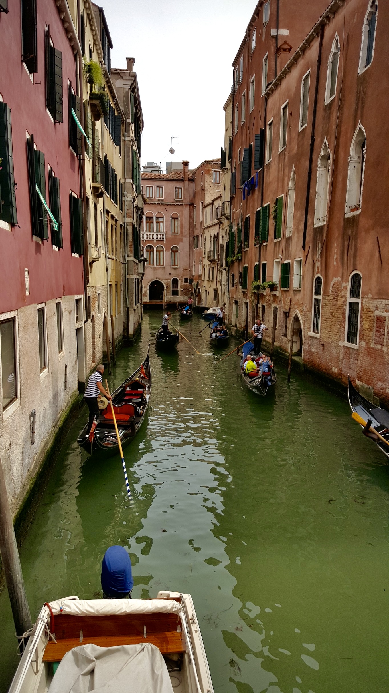 Gondola in a narrow waterway surrounded by beautiful walls